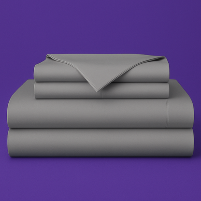 This image shows a neatly folded stack of gray bed sheets on a vibrant purple background. The stack includes what appears to be a fitted sheet, flat sheet, and pillowcases. The sheets have a smooth, crisp appearance suggesting high-quality bedding. The top sheet has a folded corner revealing the edge detail.
