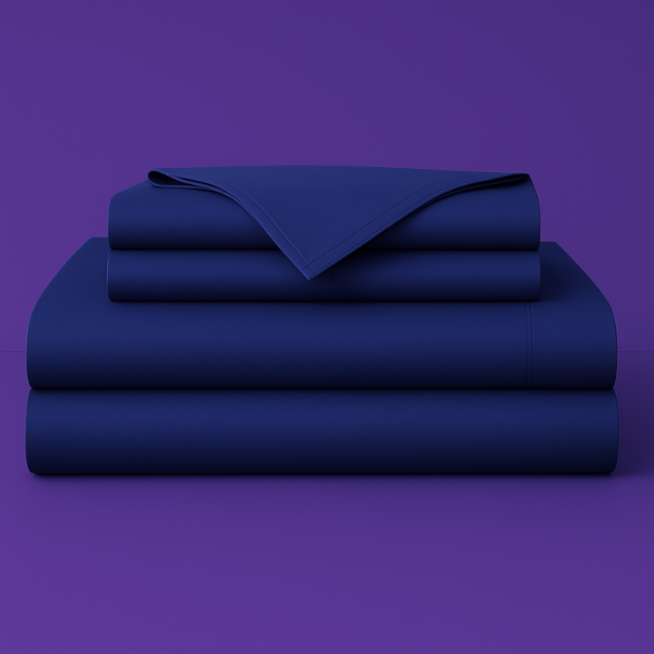 This image shows a neatly folded stack of navy blue bed sheets on a vibrant purple background. The stack includes what appears to be a fitted sheet, flat sheet, and pillowcases. The sheets have a smooth, crisp appearance suggesting high-quality bedding. The top sheet has a folded corner revealing the edge detail.
