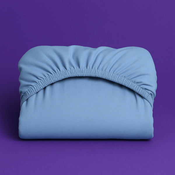 Premium light blue fitted sheet with elastic edge displayed on a vibrant purple background. The sheet features a smooth, wrinkle-resistant fabric with deep pockets and secure elastic banding that ensures a perfect fit on mattresses.