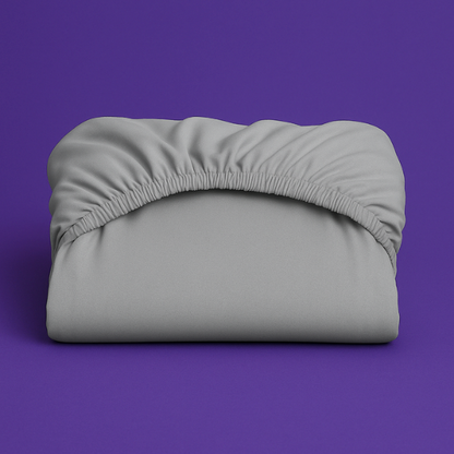 Premium gray fitted sheet with elastic edge displayed on a vibrant purple background. The sheet features a smooth, wrinkle-resistant fabric with deep pockets and secure elastic banding that ensures a perfect fit on mattresses.