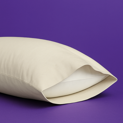 Elegant cream-colored pillowcase with a white pillow partially visible inside, set against a rich purple background. The premium pillowcase features a clean envelope closure design that securely holds the pillow while maintaining a sleek appearance.