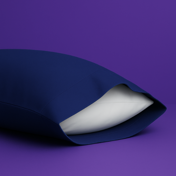 Elegant navy blue pillowcase with a white pillow partially visible inside, set against a rich purple background. The premium pillowcase features a clean envelope closure design that securely holds the pillow while maintaining a sleek appearance.