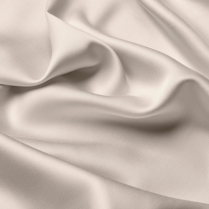Silky satin fabric with folds in a neutral beige color