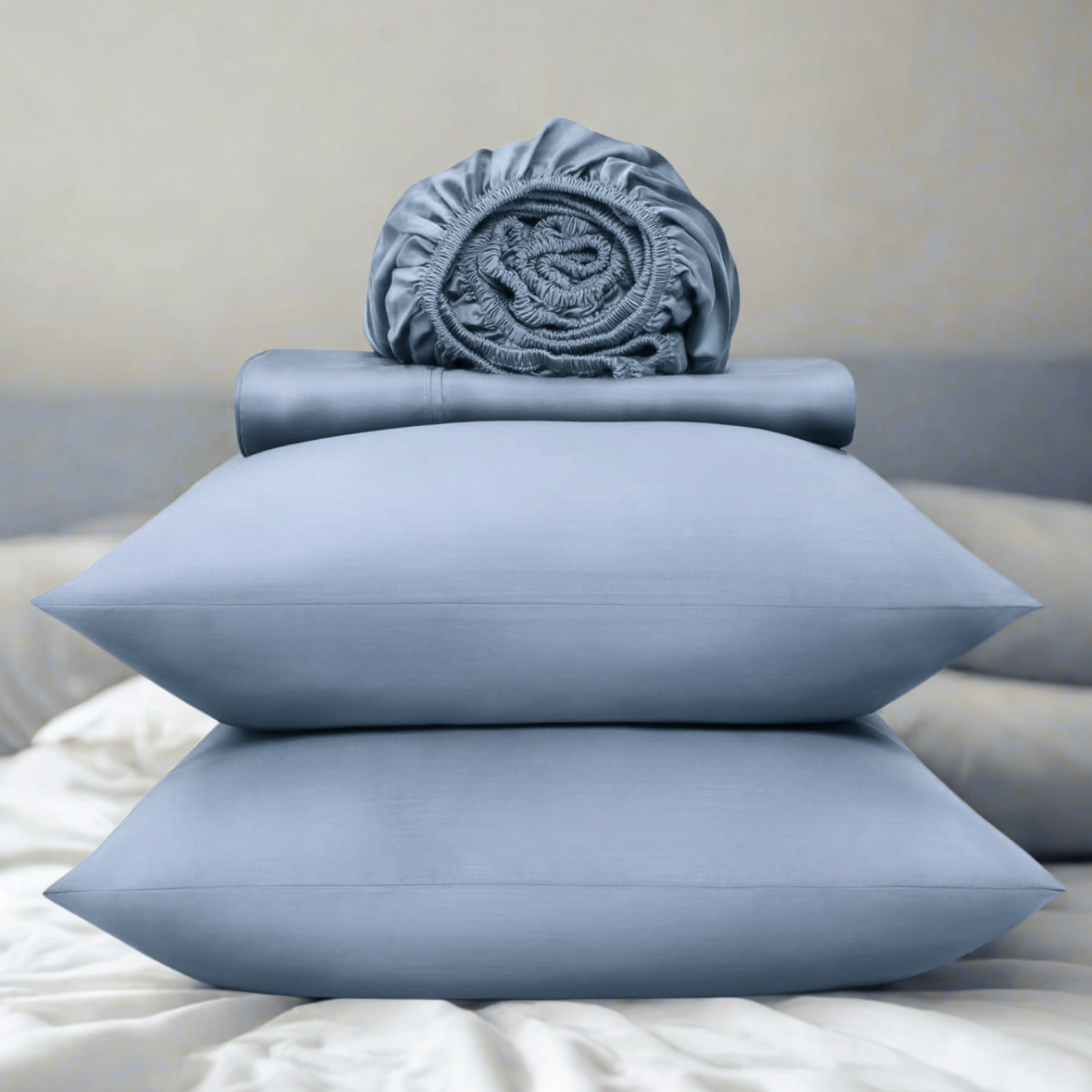 Blue bedding set including pillows and a fitted sheet on a bed.