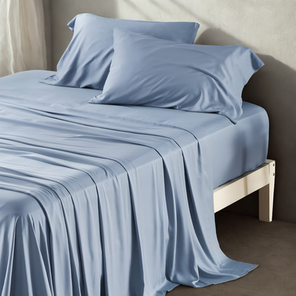 Blue bed sheets and pillows on a bed in a minimalistic room.