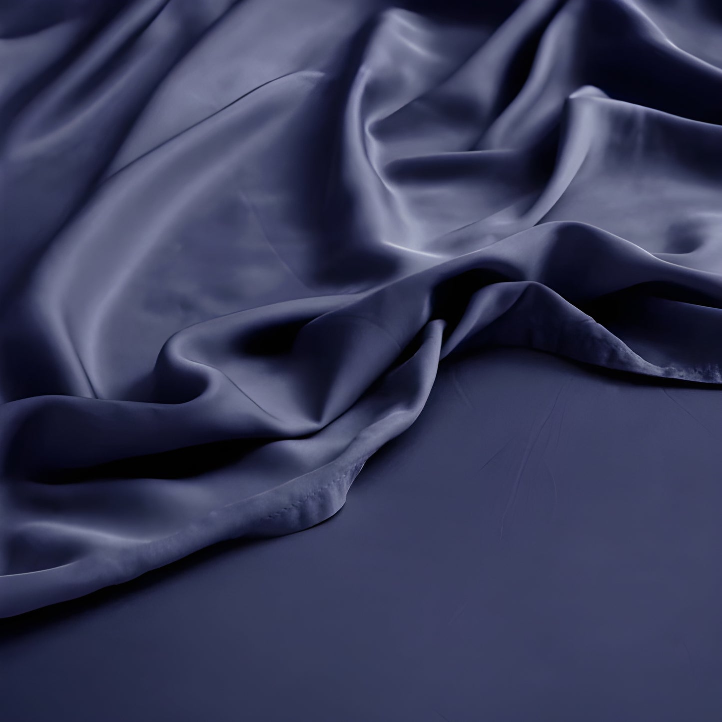 Dark blue satin fabric with folds on a dark background