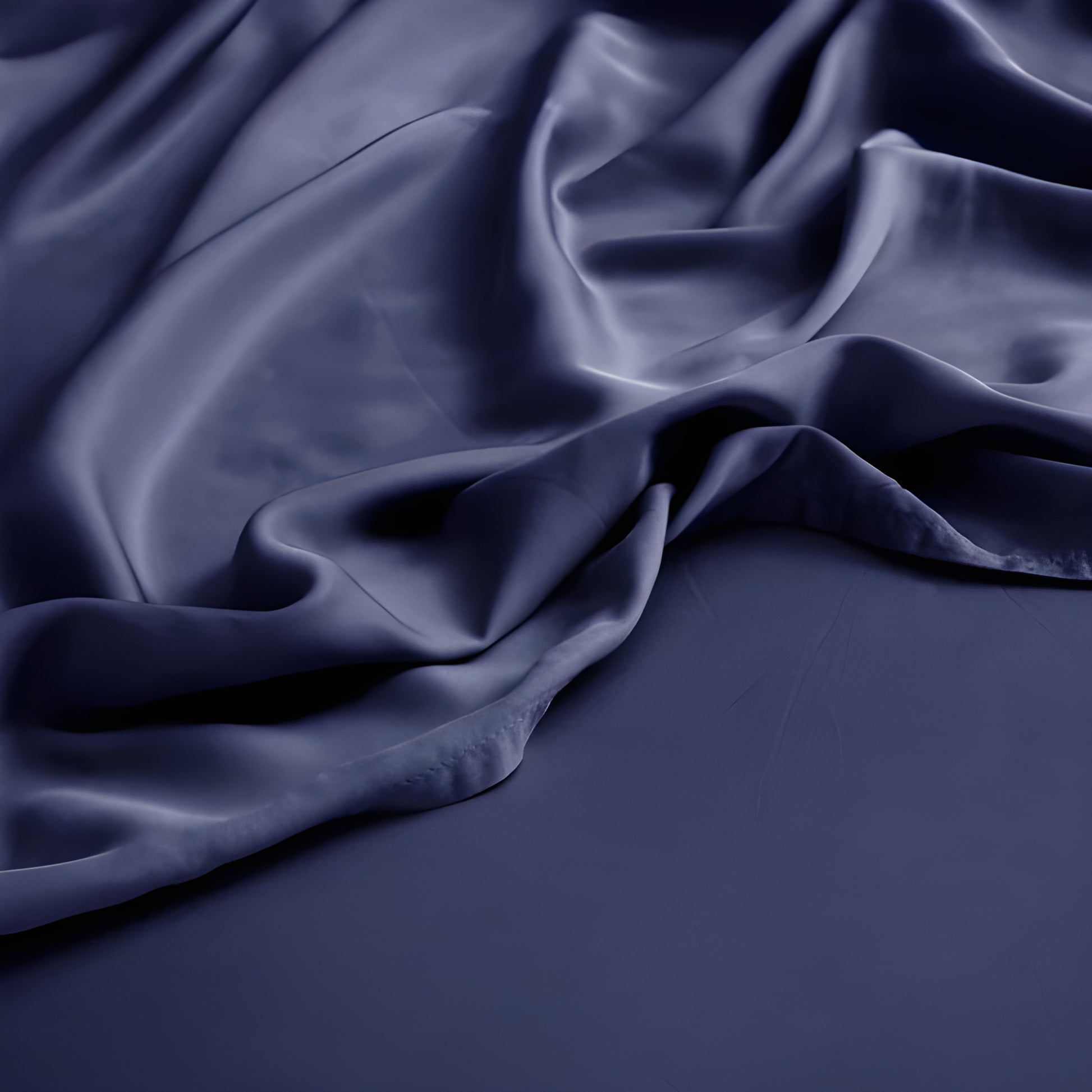 Dark blue satin fabric with folds on a dark background
