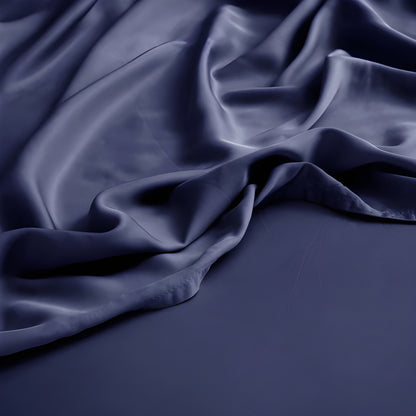 Dark blue satin fabric with folds on a dark background