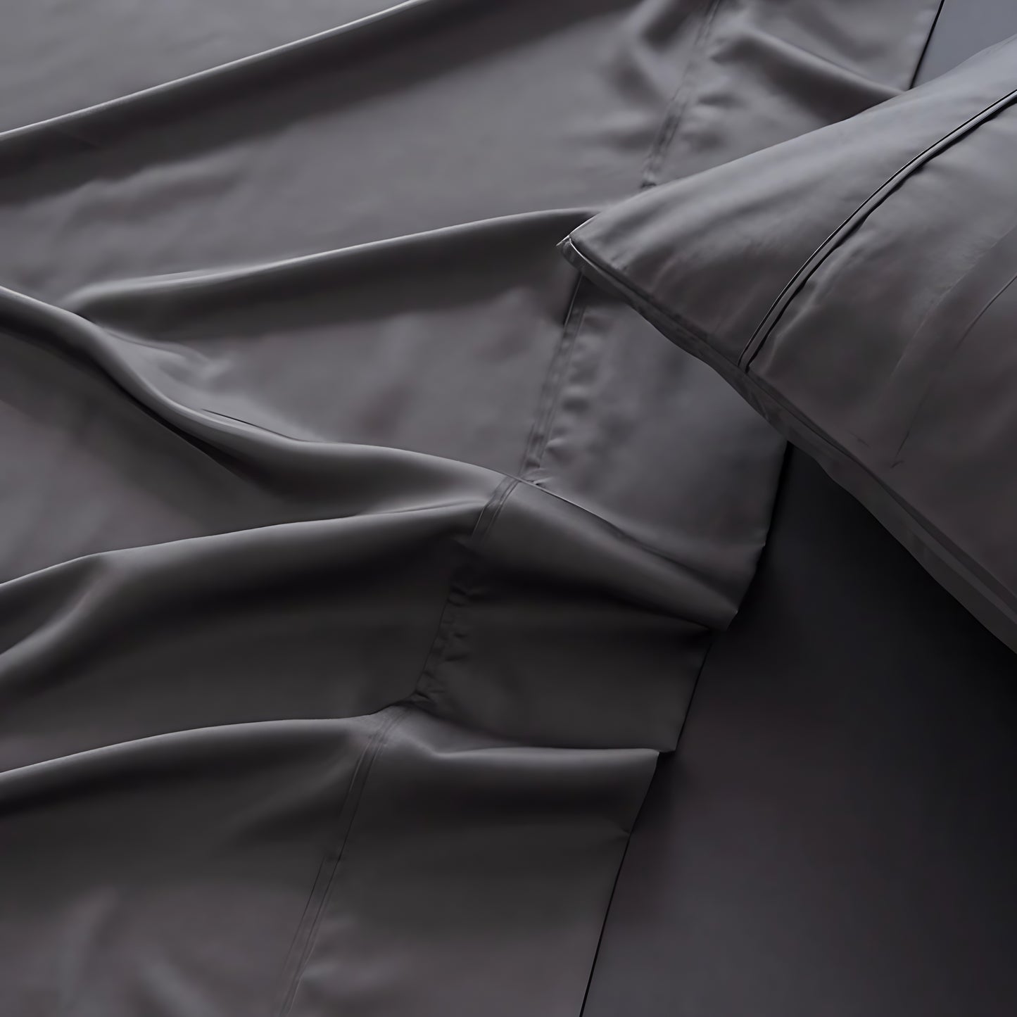 Close-up of dark gray bedding with a focus on texture and folds.