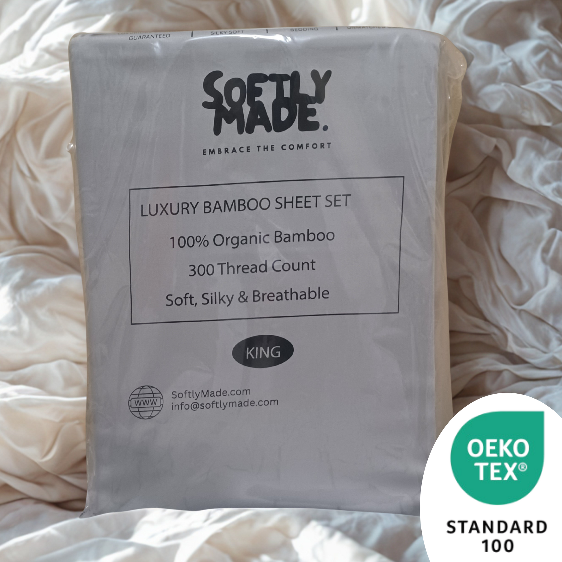 Packaged SOFTLY MADE luxury bamboo sheet set with OEKO-TEX Standard 100 logo on a bed.