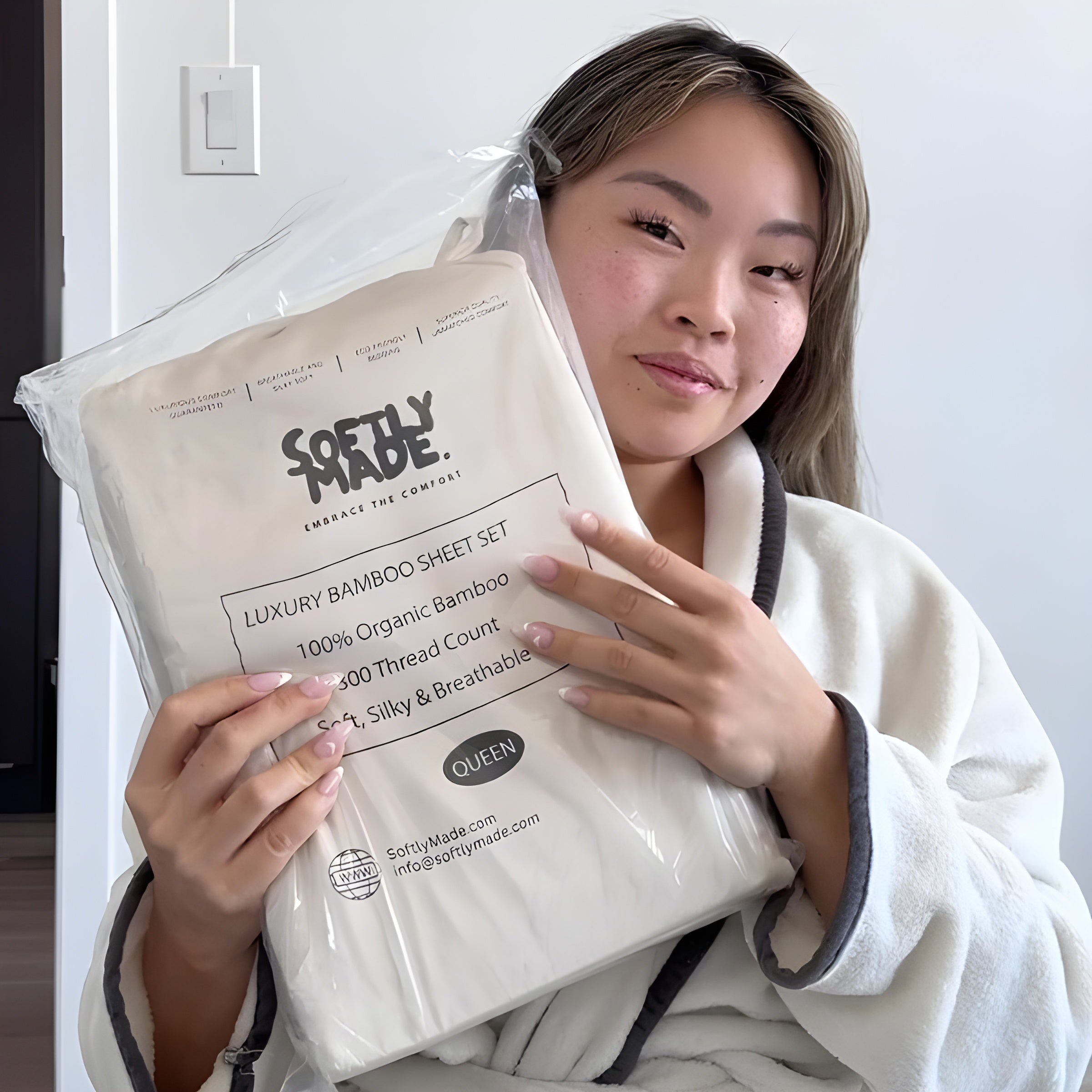 Person holding a Softly Made luxury bamboo sheet set packaging