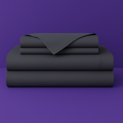 This image shows a neatly folded stack of dark grey bed sheets on a vibrant purple background. The stack includes what appears to be a fitted sheet, flat sheet, and pillowcases. The sheets have a smooth, crisp appearance suggesting high-quality bedding. The top sheet has a folded corner revealing the edge detail.