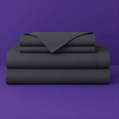 This image shows a neatly folded stack of dark grey bed sheets on a vibrant purple background. The stack includes what appears to be a fitted sheet, flat sheet, and pillowcases. The sheets have a smooth, crisp appearance suggesting high-quality bedding. The top sheet has a folded corner revealing the edge detail.