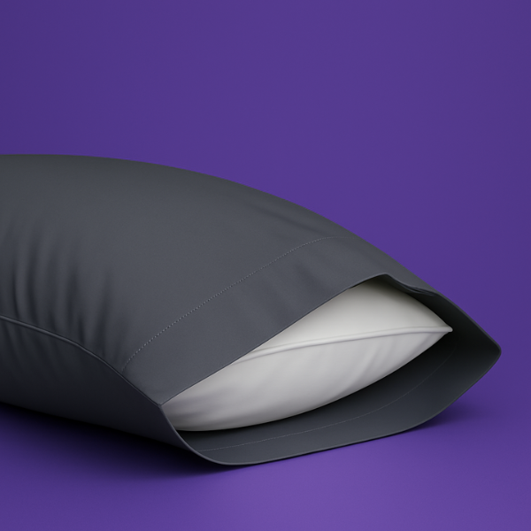 Elegant dark gray pillowcase with a white pillow partially visible inside, set against a rich purple background. The premium pillowcase features a clean envelope closure design that securely holds the pillow while maintaining a sleek appearance.