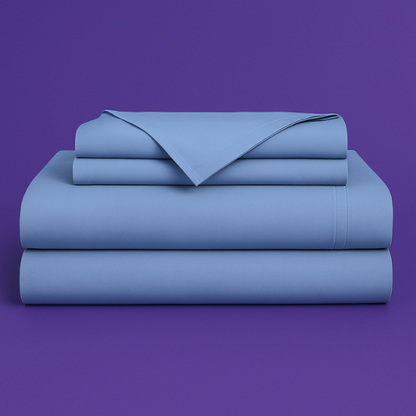 This image shows a neatly folded stack of light blue bed sheets on a vibrant purple background. The stack includes what appears to be a fitted sheet, flat sheet, and pillowcases. The sheets have a smooth, crisp appearance suggesting high-quality bedding. The top sheet has a folded corner revealing the edge detail.