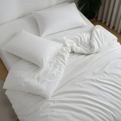 SoftlyMade complete white bedding set on minimalist bedroom with bamboo sheets, duvet cover, and pillowcases. Organic luxury bedding with natural wrinkle texture for comfortable sleep in modern home setting with plant decor.